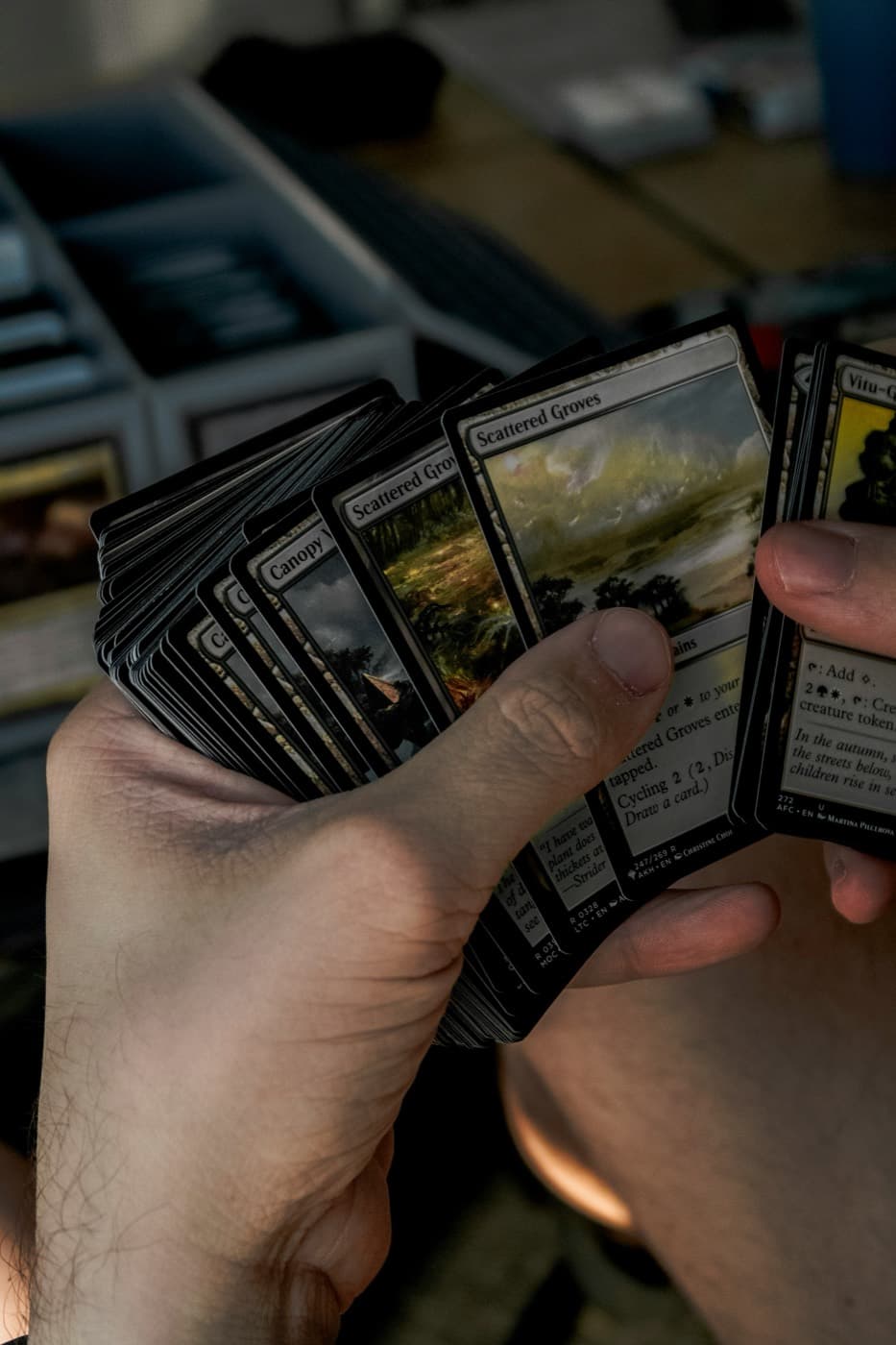 Main de joueur tenant un éventail de cartes Magic: The Gathering